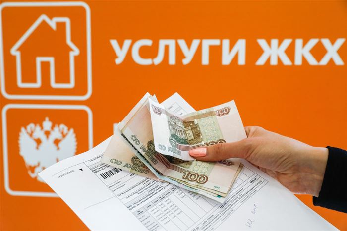 Квитанция и деньги в женской руке на фоне вывески "Услуги ЖКХ"